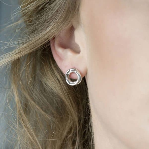 Model wearing silver bonds of friendship earrings