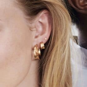 Model wearing pernille corydon midi saga hoop earrings